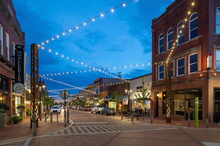 Trade Street at night with festival lights criss-crossing above the street